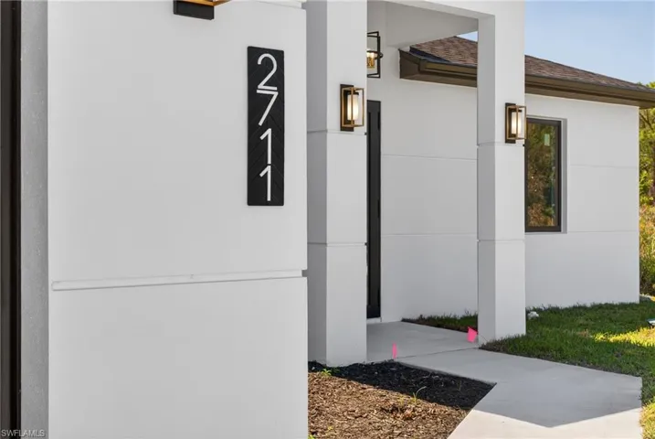 Entrance to property with stucco siding and roof with shingles
