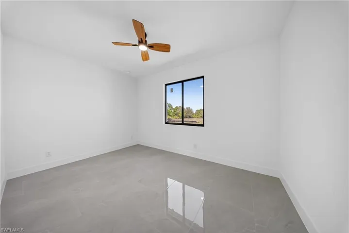 Spare room featuring baseboards and ceiling fan