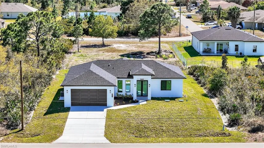 View of front of home featuring a shingled roof, stucco siding, concrete driveway, an attached garage, and a residential view