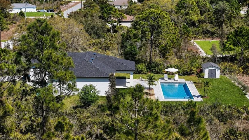 Contemporary residence featuring a dark shingle roof and white exterior