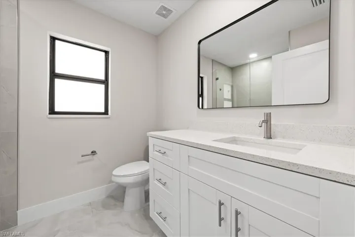 Guest Bathroom featuring light marble finish flooring and vanity