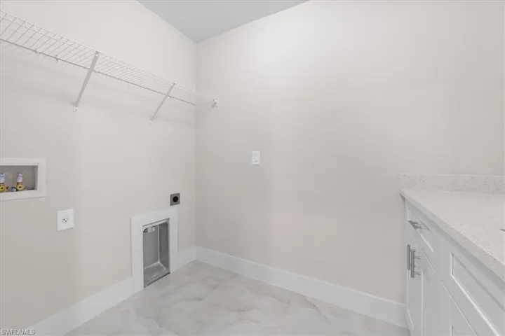 Laundry area with granite countertops and laundry sink. Washer and dryer are included.
