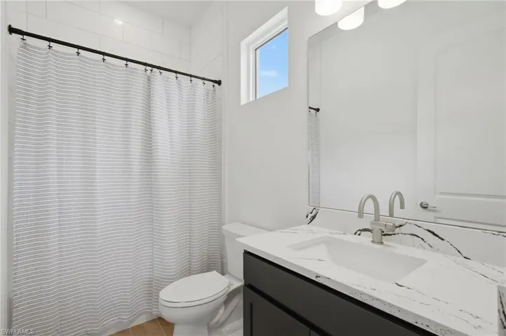White subway tile shower surround with a dark-finish shower rod