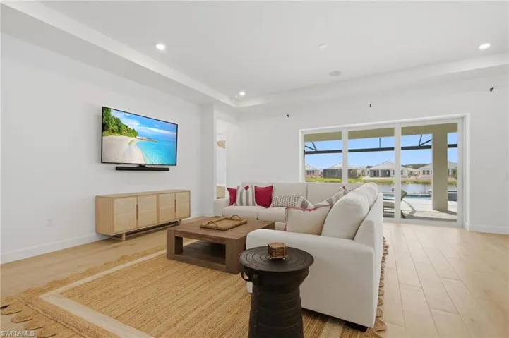 Recessed lighting, wood-finish flooring, and white walls