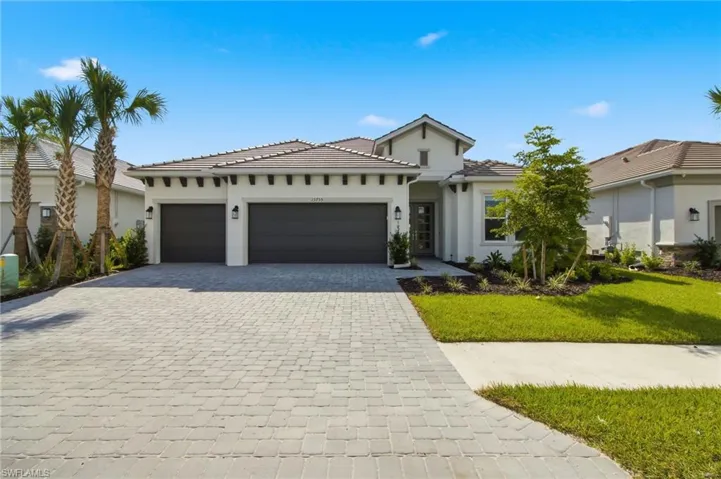 Contemporary exterior with a tile roof, paver driveway, two-car garage, and established landscaping