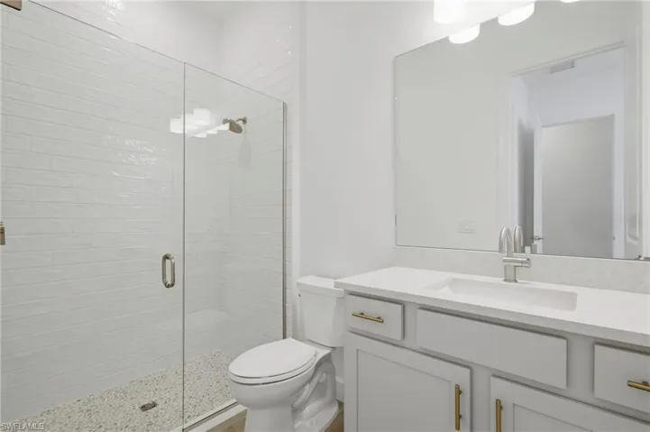 Walk-in shower with clear glass enclosure and subway tile surround