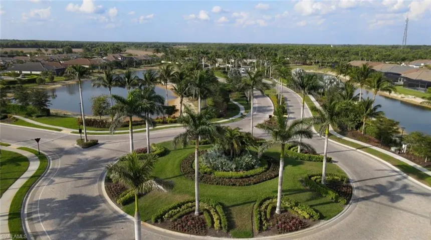 Gated Entrance, Walking paths, Manicured landscaping, mature palm trees, paved roadways, and water features define the community