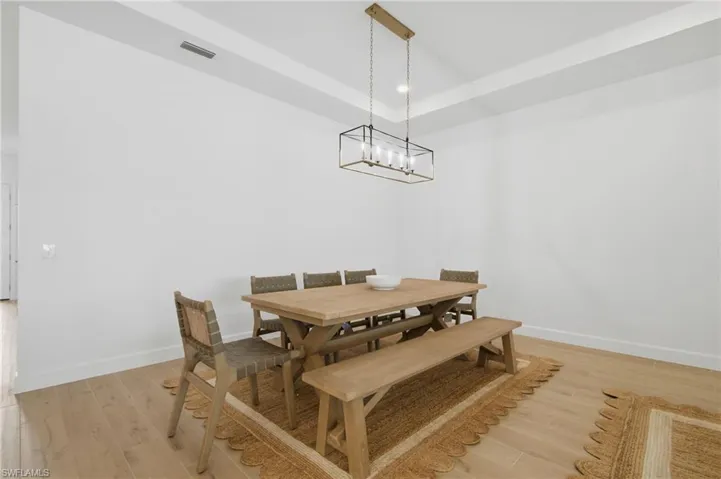 Recessed ceiling, wood-finish flooring, and a linear chandelier