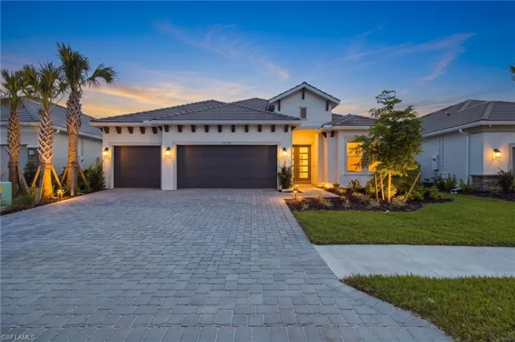 Exterior featuring a paver driveway, stucco siding, and a tiled roof