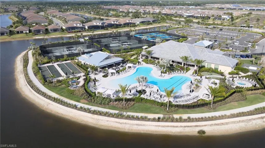 Community club building with a multi-level pool, adjacent tennis courts, and bocce ball courts