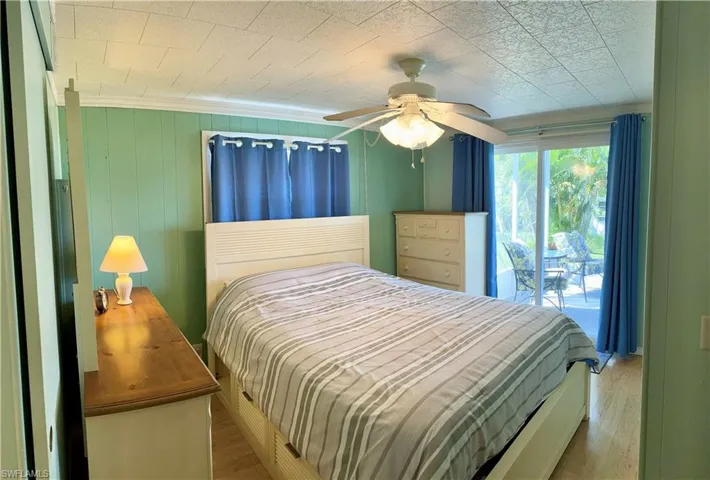 Bedroom with ceiling fan & light, with access to outside screen room, and ceiling fan