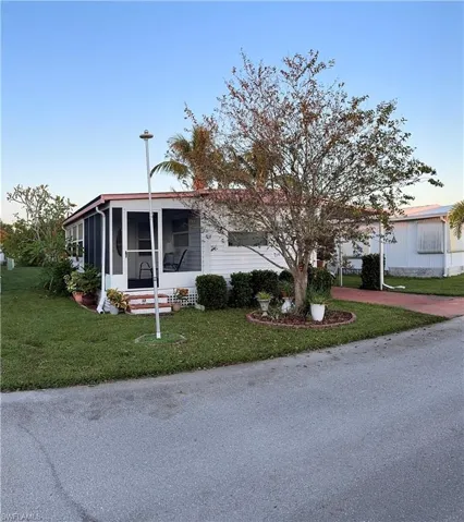 View of front of property with a front lawn and a sunroom