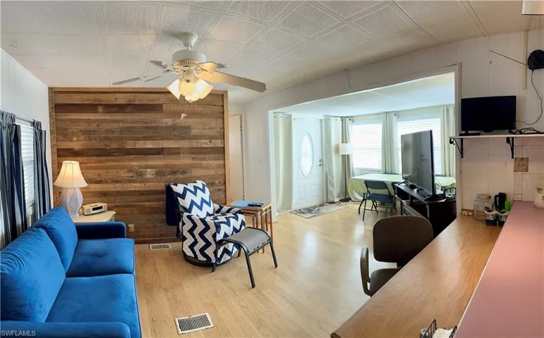 Livingroom featuring wooden walls, and ceiling fan