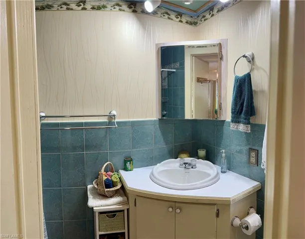 Bathroom with vanity and tile walls