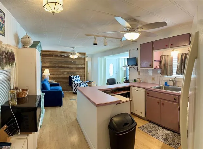Kitchen featuring white dishwasher, sink, kitchen peninsula
