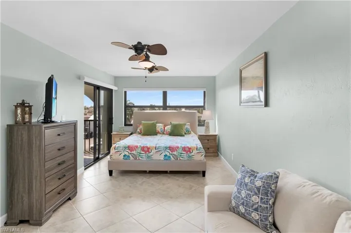 Large bedroom, Hunter Douglas electric window shades, king-size bed, lanai access, ceiling fan and closet