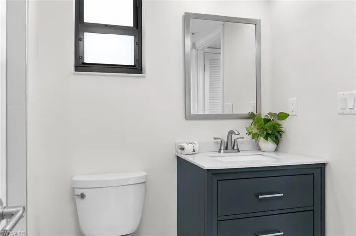 White tiled glass walk-in shower with navy blue cabinet