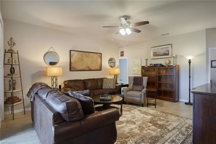 Living area with ceiling fan and light tile patterned floors