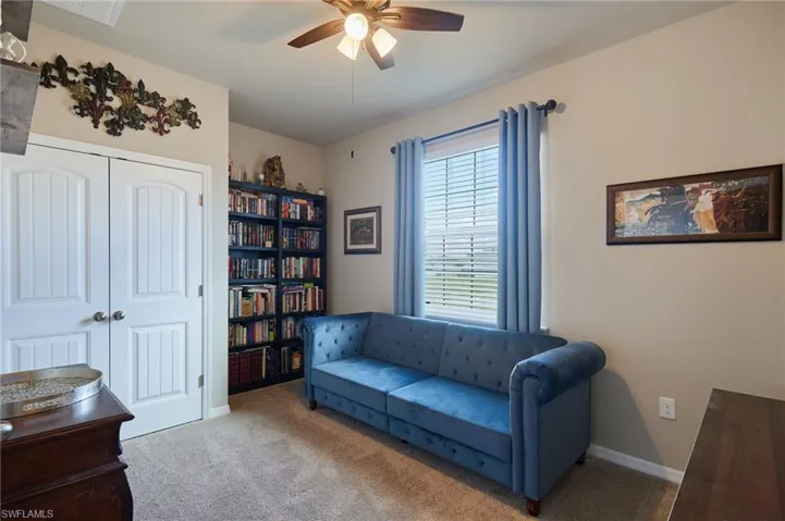 Living area featuring ceiling fan and carpet flooring