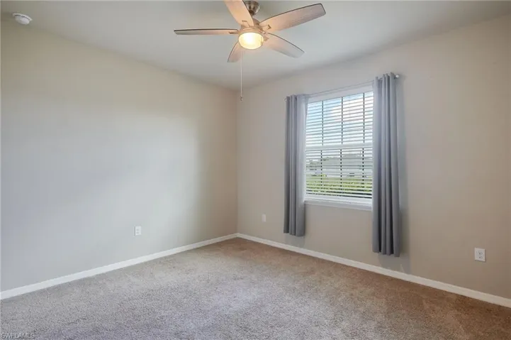 Guest bedroom featuring carpet, a ceiling fan, and a smoke detector