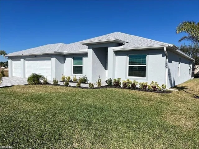 View of front of home featuring stucco siding, a front yard, driveway, an attached garage, and roof with shingles