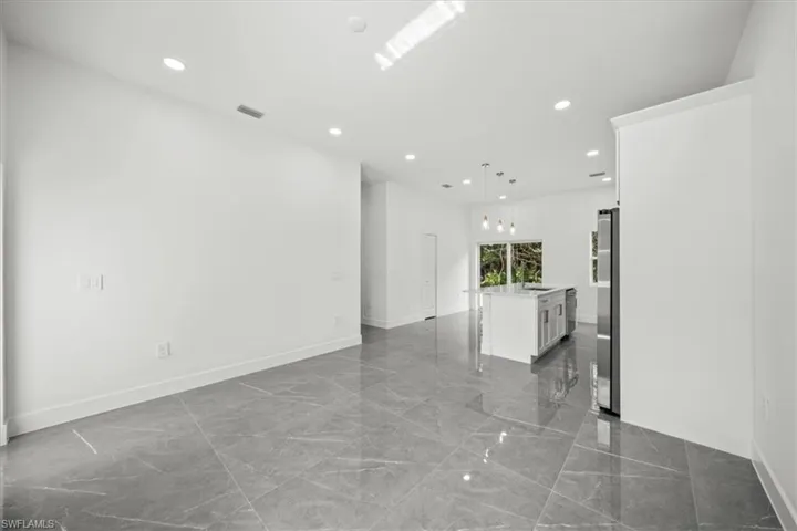 Unfurnished living room with marble tiled floors and recessed lighting
