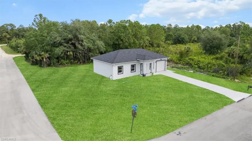 View of front of home with driveway, a front lawn, a garage, and stucco siding