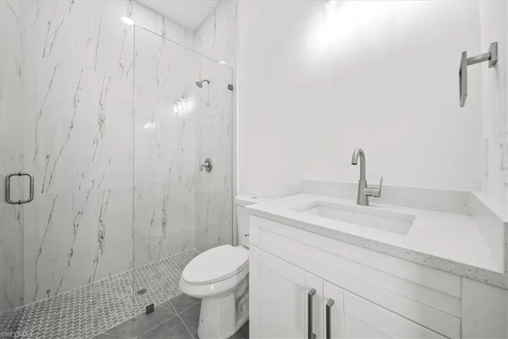 Bathroom with vanity and a marble finish shower