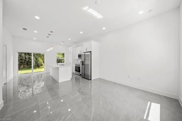 Unfurnished living room with recessed lighting and light marble finish floors