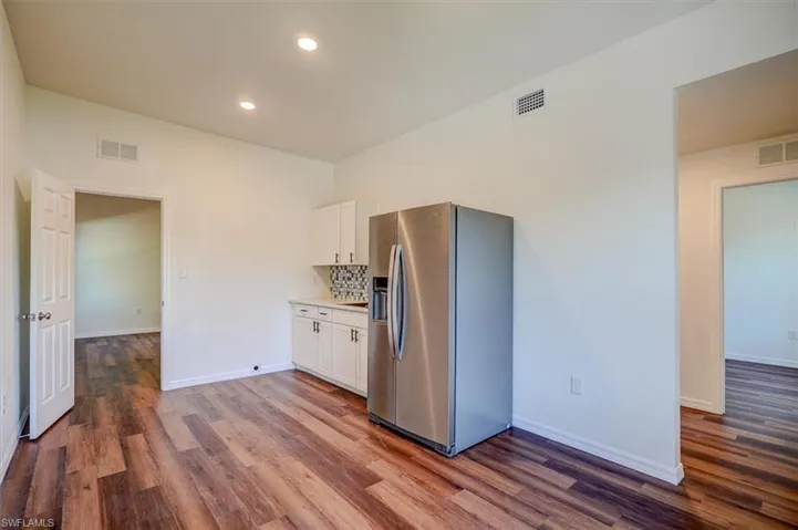 In law Kitchenette Kitchen with dark wood-style floors, stainless steel fridge with ice dispenser, and visible vents