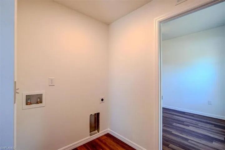 In Law Laundry area area with electric dryer hookup, baseboards, dark wood-type flooring, laundry area, and washer hookup