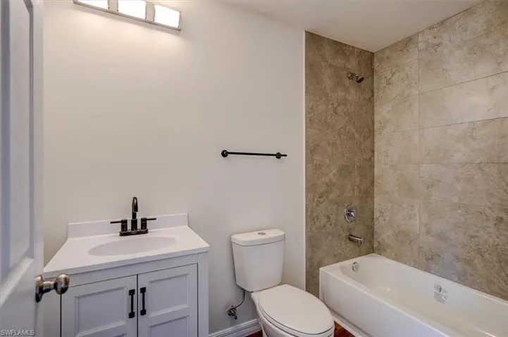 Full bath with tub / shower combination, toilet, and vanity