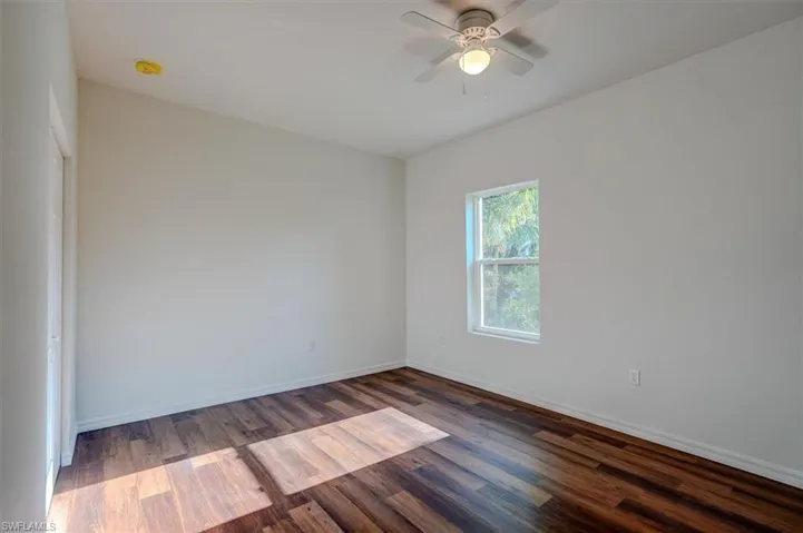 Unfurnished room featuring baseboards, a ceiling fan, and wood finished floors