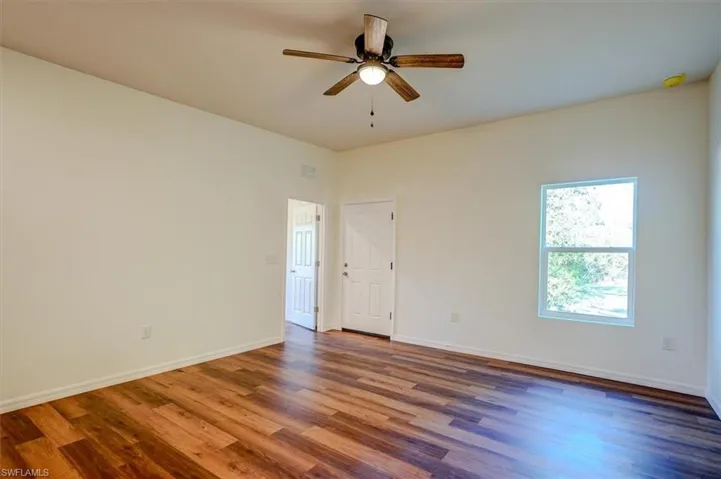 Empty room featuring baseboards, a ceiling fan, wood finished floors, and visible vents