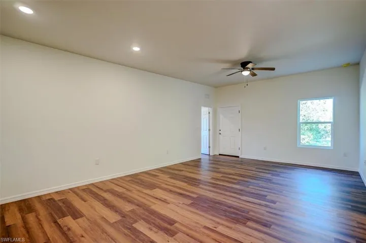 Empty room with recessed lighting, wood finished floors, a ceiling fan, and baseboards