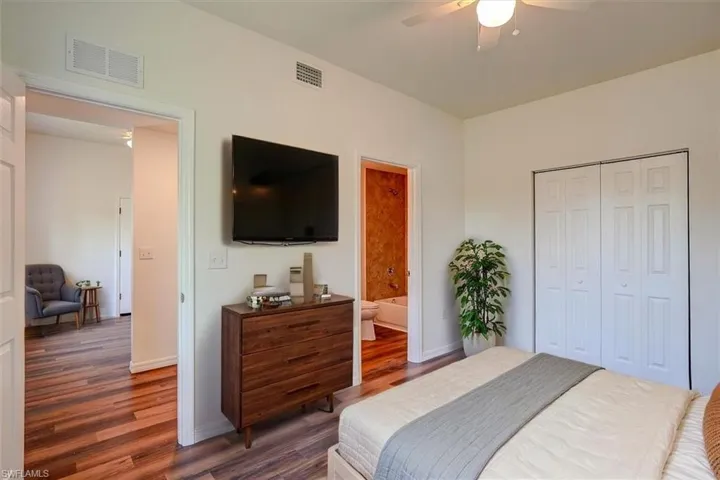 Bedroom featuring a closet, wood finished floors, visible vents, and ceiling fan