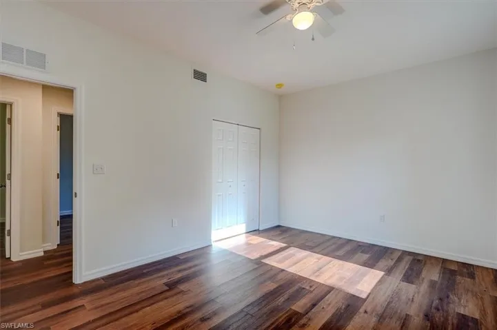 Unfurnished bedroom featuring baseboards, wood finished floors, and visible vents