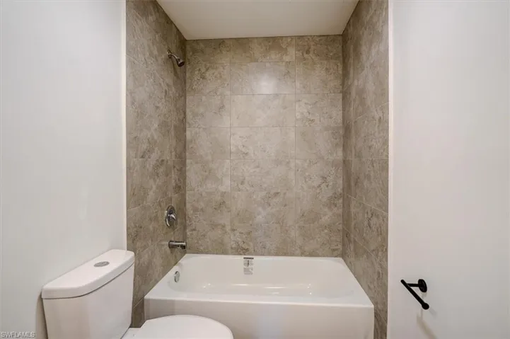 Bathroom featuring bathtub / shower combination and toilet
