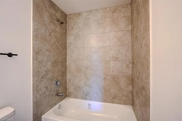 Bathroom with toilet and shower / washtub combination