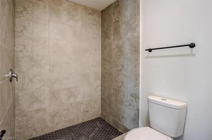 Full bathroom featuring a tile shower and toilet