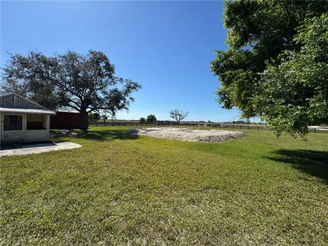 View of yard with a rural view and fence