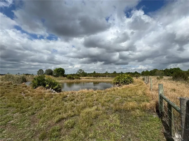 Property view of water with a rural view and fence