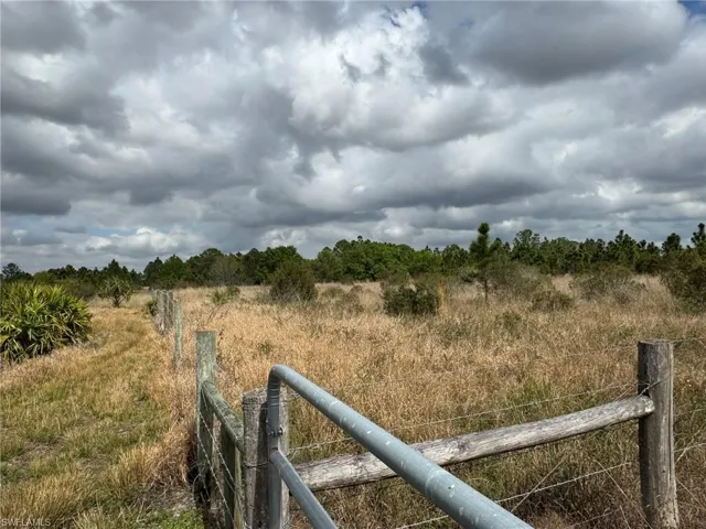 View of yard featuring a rural view and fence