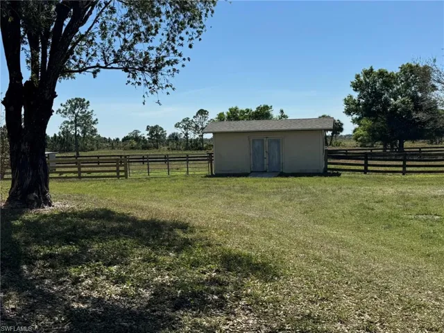 View of yard with fence and a rural view