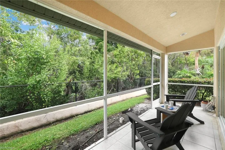 Screened in lanai with vaulted ceiling offers amazing natural light and a view of preserve and can be accessed via glass sliding doors in living room and primary bedroom