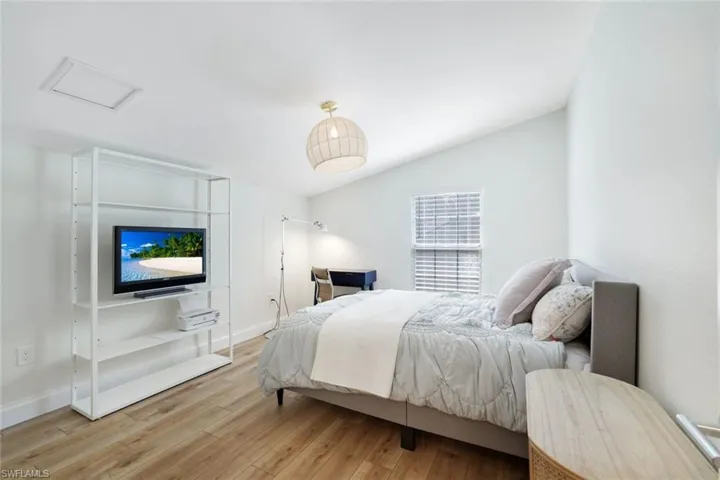 Upstairs bedroom with en suite bathroom features lofted ceiling and light wood-style flooring, can also be used as an office