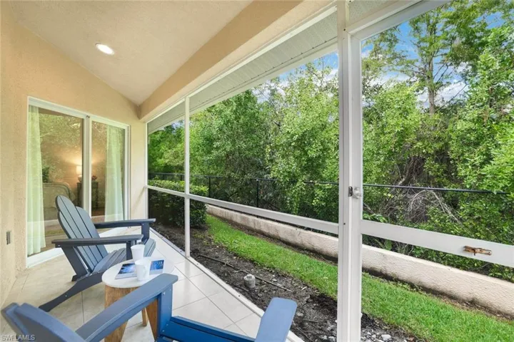 Screened in lanai with vaulted ceiling offers amazing natural light and a view of preserve and can be accessed via glass sliding doors in living room and primary bedroom