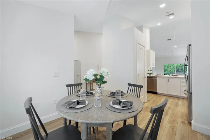 Dining space off of the open kitchen can also be used as a den or home office. The space features an abundance of natural light, contemporary light-style wood flooring and ceiling fan