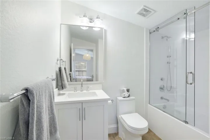 Completely renovated upstairs full bathroom includes custom wood cabinetry and vanity, new toilet, wood-style flooring, with a shower and deep soaking tub bath