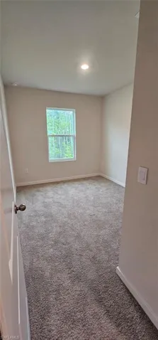 Neutral tone painted walls, a single window, recessed ceiling lighting, and wall-to-wall carpeting